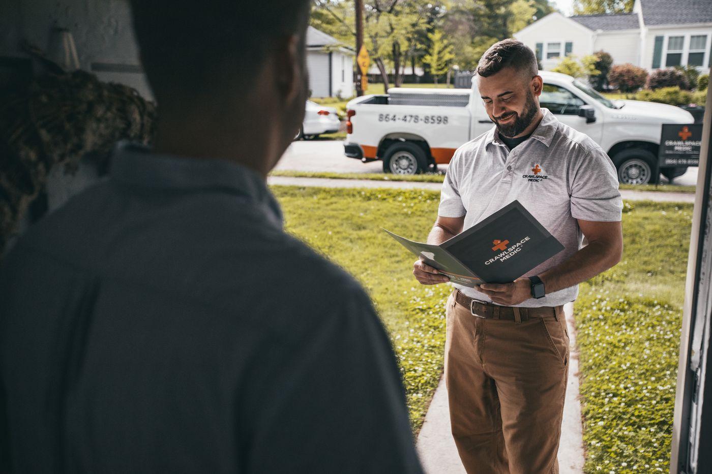 A Crawlspace Medic inspector walking a homeowner through the findings.