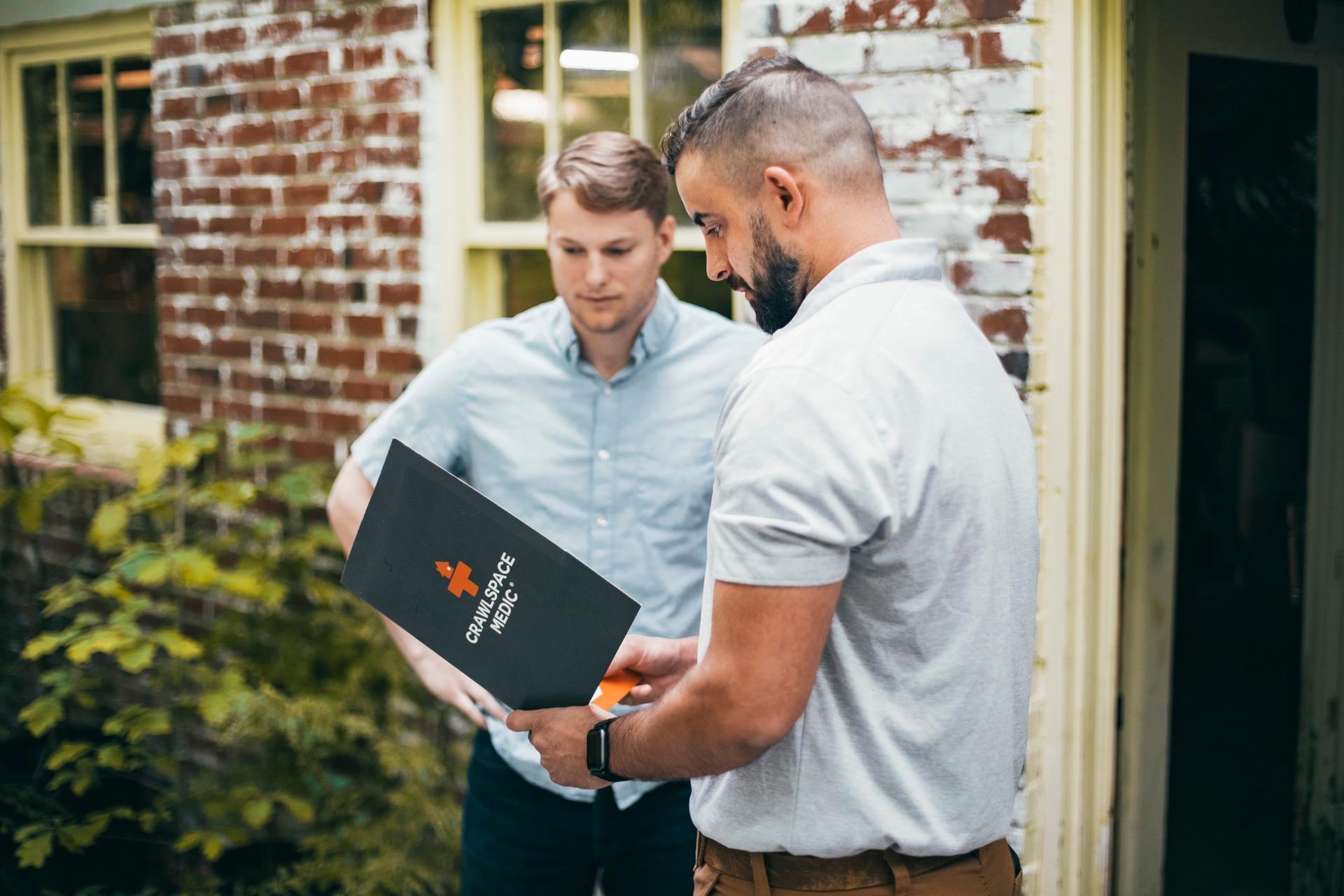 A Crawlspace Medic specialist reviewing inspection findings with a homeowner